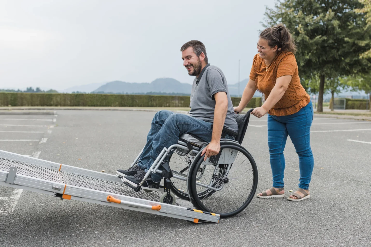 Friendly support worker assisting an NDIS participant into a comfortable vehicle in Rockingham, Western Australia